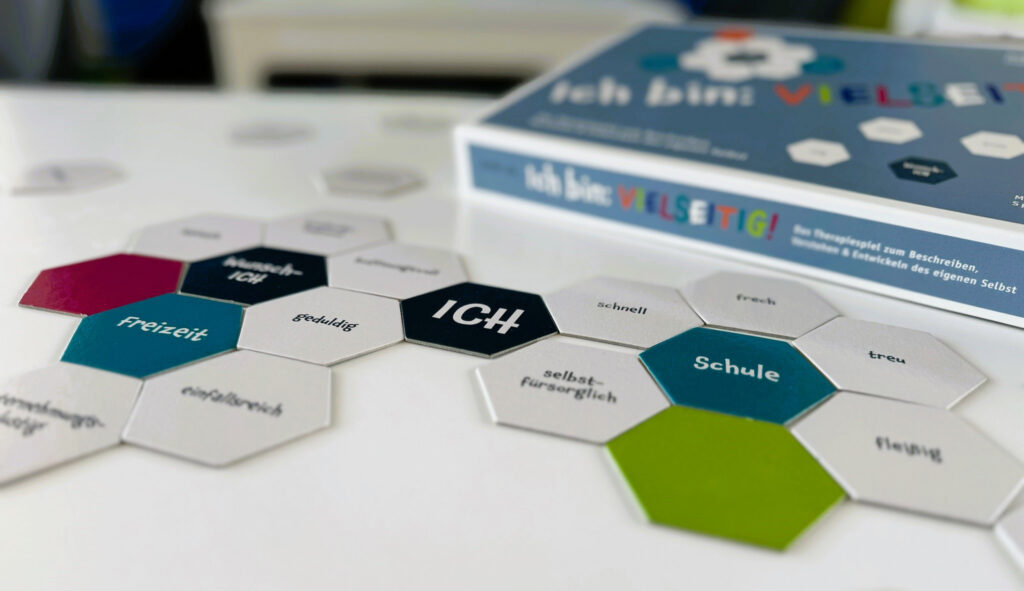 Therapiespiel „Ich bin: vielseitig!“ mit Wabenkärtchen zu Stärken und Lebensbereichen auf einem Tisch – spielerische Methodik in der Betreuung bei levelUP